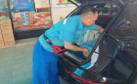 加油站员工为顾客提供装车服务 加油站员工为顾客提供装车服务