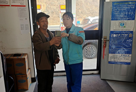 通化榆林站帮助村里老人操作手机。孙晶/供图 通化榆林站帮助村里老人操作手机。孙晶/供图