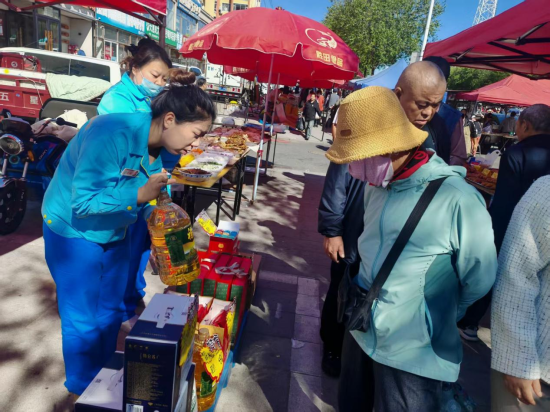 延边分公司延南站员工在市集推荐家庭食品。 陈兵/供图 延边分公司延南站员工在市集推荐家庭食品。 陈兵/供图